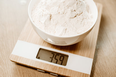 Flour in a plate stands on a kitchen scale, homemade food according to recipes