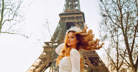 Incredibly beautiful brunette against the backdrop of the Eiffel Tower with flowing hair. French beauty secretsの写真素材