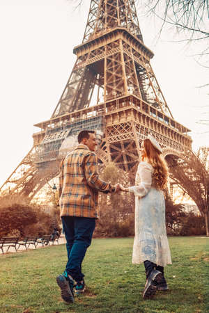 A couple in Paris with the Eiffel Tower in the background. Romantic trip, honeymoon in Europe. France city of love. Follow me. Love.の写真素材