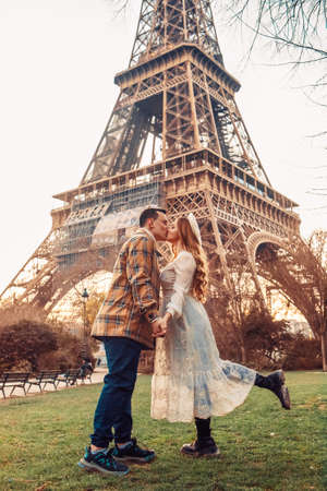 A couple kissing in front of the Eiffel Tower in Paris. Romantic trip, honeymoon in Europe. France city of love.の写真素材