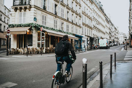 Paris, France. The architecture of the city and streets, beautiful houses and the city. postcard Man riding a bikeの写真素材