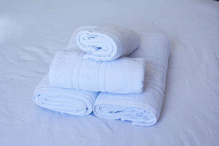 Towels in the hotel lie on the bed, hand and face towelsの写真素材