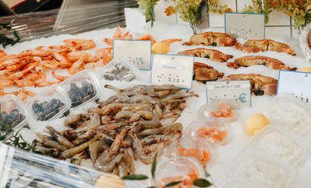 Seafood stall on the street, salmon, shrimp and white fish, a large selection of healthy food in the marketの写真素材