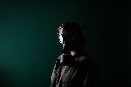 Photo of a military man in a gas mask, apocalypse, nuclear weapons, atomic explosion of a station, chemical and nuclear weapons protection. Girl in a mask on a green background, warの写真素材