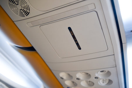 Aircraft inside, rows of seats, light in transport, hood and place where the mask drops out, panel above the seatの写真素材