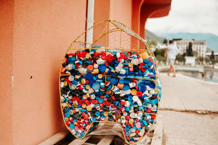 On the beach, bottle caps are collected in a container. Caring for the cleanliness of the planet and the beachの写真素材