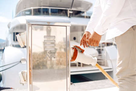Men's hands refuel their yacht. Fuel station for yachts and boats.の写真素材