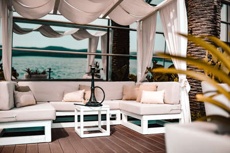 Lounge place by the sea or ocean, hookah on the table in a restaurant or home.の写真素材