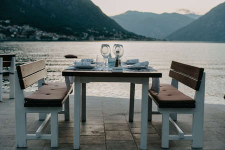 Restaurant Against the backdrop of the mountains. Cafe right by the sea. Reserved table for dinner dateの写真素材