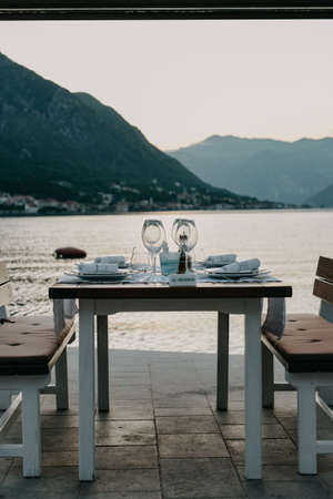 Restaurant Against the backdrop of the mountains. Cafe right by the sea. Reserved table for dinner dateの写真素材