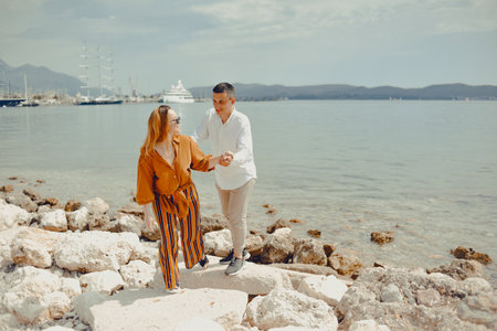 A couple walks along the beach against the backdrop of the sea and mountains. Travel of lovers. Love and honeymoonの写真素材