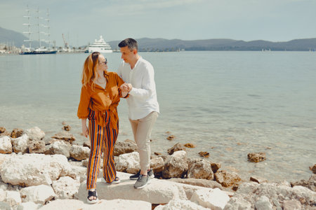 A couple walks along the beach against the backdrop of the sea and mountains. Travel of lovers. Love and honeymoonの写真素材