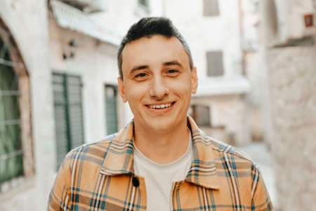 Portrait of a guy on the background of the old city. Man smiling and looking at the camera