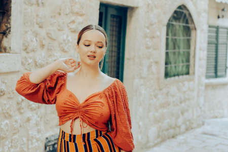 A very beautiful woman is walking on the street. The model poses for a photo in the old city on a trip. Tourismの写真素材