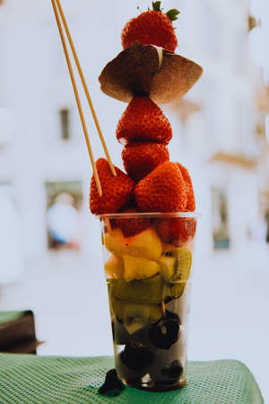 Fruit diet, fruits in a cup, strawberries, coconut and pineapples with kiwi. Italian snack. Healthy lifestyleの写真素材