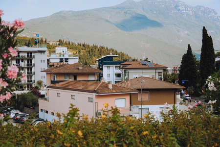 Italy. Trentino 07/09/2022 Riva del Garda. Houses and architecture of the city against the backdrop of mountains. Beauty and vacation, summer day, travel, flowers and city viewの写真素材