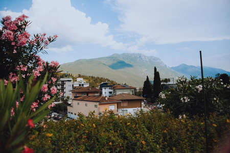 Italy. Trentino 07/09/2022 Riva del Garda. Houses and architecture of the city against the backdrop of mountains. Beauty and vacation, summer day, travel, flowers and city viewの写真素材