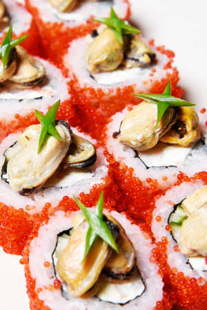 Elite sushi on a white background in red tobiko caviar with mussels on top. Foodの写真素材