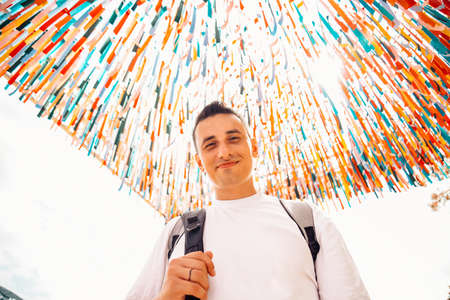 A man at the festival looks at the camera and smiles against a colorful backgroundの写真素材