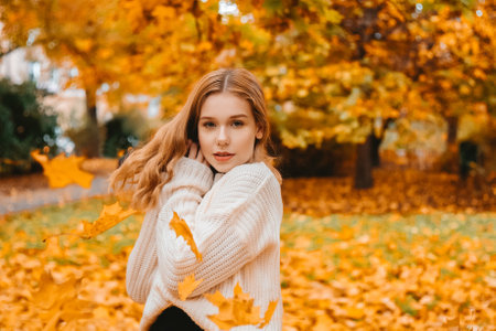 Photo portrait of a girl in a white sweater, beautiful brunette. Pretty woman in the park in autumn Autumn fashion and styleの写真素材