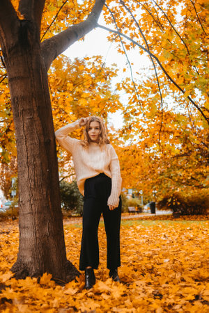 Photo of a girl in an autumn park in full growth. Fashionable woman.の写真素材