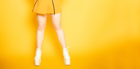 Girl's legs on a bright orange background with very high heels. Go-go or strip dancing. shoe storeの写真素材