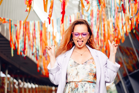 A girl in a dress, jacket and purple sunglasses poses at the festival. Party and danceの写真素材