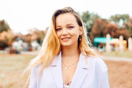 Portrait of a beautiful girl with a fashionable hairstyle at the festival. woman with makeup looking...