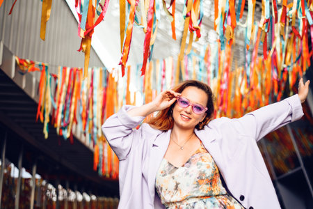 A girl in a dress, jacket and purple sunglasses poses at the festival. Party and danceの写真素材