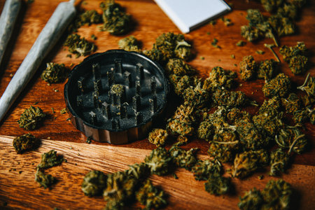 Grinder close shot, grass and cones, drugs in joint on a wooden table.の写真素材