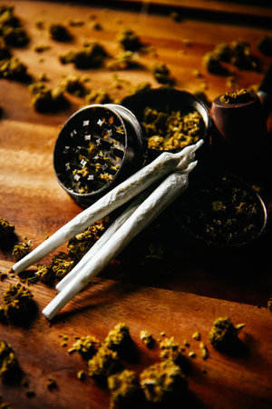 Grinder and joints with marijuana pipe. Drugs and marijuana, marijuana buds. Sativa and indica Ñbd and tgk on wood. Grass and smoking plants.の写真素材