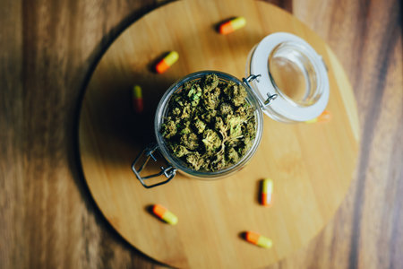 Marijuana in medicine and treatment. Marijuana buds and pills in a glass jarの写真素材