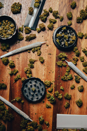 Grinder close shot, grass and cones, drugs in joint on a wooden table. Drug Dealer's House.の写真素材