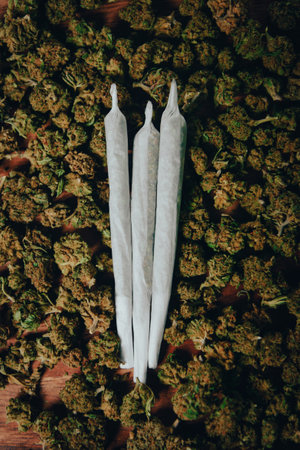 Joints are on the table. Three crossed joints in marijuana buds, indica sativa Ñbd medicinalの写真素材