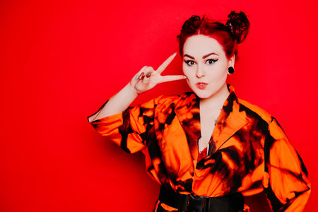 Beautiful girl on a red background. Red hair and tunnels in the ears, red dress and lips. anime...