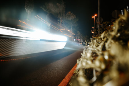 A road with cars at night on a long exposure. Travel at night in a warm country with palm trees, rent a carの写真素材