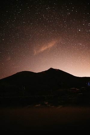 Mountains at night and stars in the sky, the big bear, falling stars and planets in the sky. Noisy photo at long exposureの写真素材