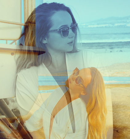 Fashion photo of a woman sun glasses beach near the sea or ocean, beautiful happy women, beautiful summer sunset light, contrast photo on photo exposureの写真素材