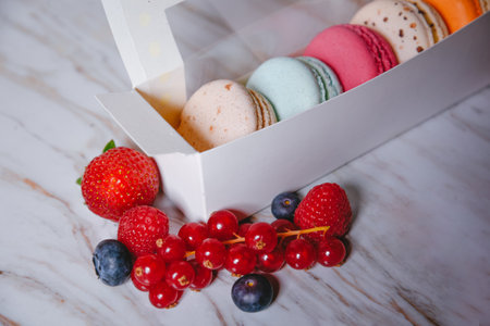 Macaron dessert, a box with colorful macarons lies on a marble style. Sweets, diet, gift for March 8...