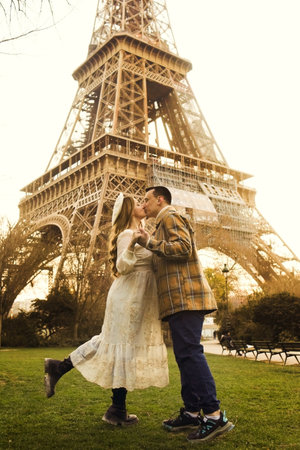 A couple kissing in front of the Eiffel Tower in Paris. Romantic trip, honeymoon in Europe. France city of love.の写真素材