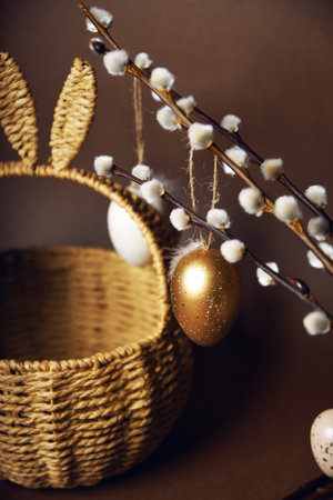 Easter decorations, a basket with cute rabbit ears. Painted eggs hang on pussy willow branches. spring has comeの写真素材