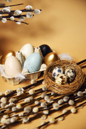 Easter holidays, pussy willow, colorful painted eggs in a tray on a nude background, warm. Religion and traditions, place for textの写真素材