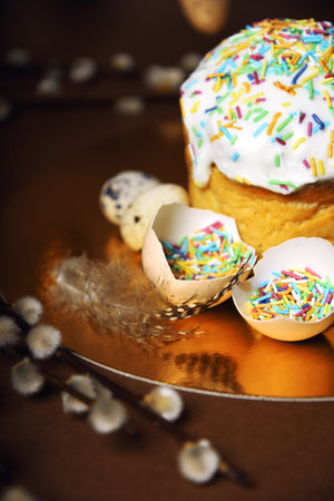 Homemade Easter cake, colored sprinkles in a shell. Quail eggs in hay, restaurant serving food. Easter and holidays on brown, Pussy willow, interesting decorations from golden eggs. restaurant servingの写真素材