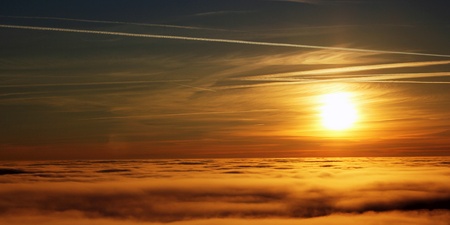 A sunset above the clouds and fog