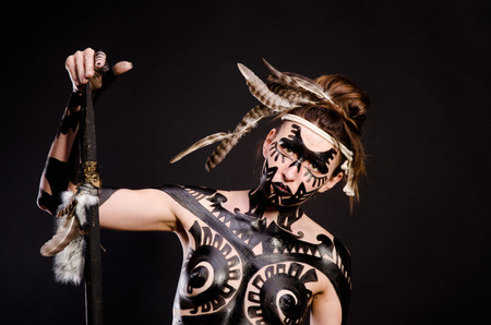 girl painted with black paint in the image of warrior women on a black background