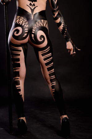 girl painted with black paint in the image of warrior women on a black backgroundの写真素材