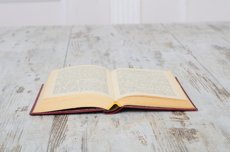 Vintage book, open, on old wooden table.の写真素材