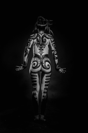 girl painted with black paint in the image of warrior women on a black backgroundの写真素材