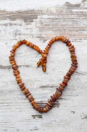 Bright orange amber necklace of raw beads Necklace of amber beads Amber beads string on an old gray wooden backgroundの写真素材