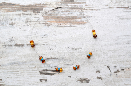 Bright orange amber necklace of raw beads Necklace of amber beads Amber beads string on an old gray wooden backgroundの写真素材
